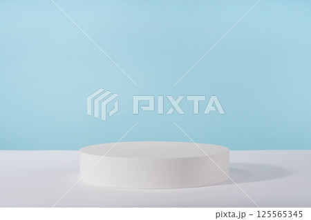Podium pedestal for cosmetic product packaging on blue background. Showcase for jewellery presentation, white platform for perfume advertising, cosmetics stand background, branding scene Podium pedestal for cosmetic product packaging on blue background. Showcase for jewellery presentation, white platform for perfume advertising, cosmetics stand background, branding scene 125565345