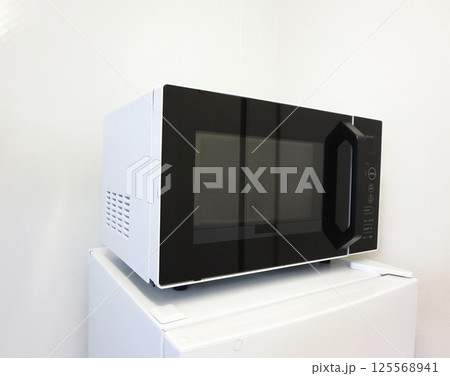 冷蔵庫の上に置ける単身用の便利な電子レンジ 125568941