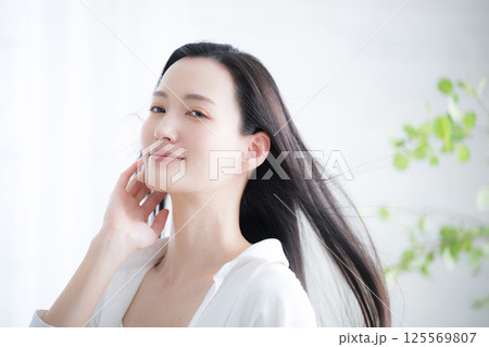 若い女性の流れる長い黒髪のヘアケアや美容のビューティーイメージ 風になびく女性 若い女性の流れる長い黒髪のヘアケアや美容のビューティーイメージ 風になびく女性 125569807