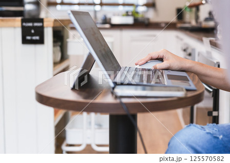 Focus on woman hand holding computer mouse while working on laptop. Focus on woman hand holding computer mouse while working on laptop. 125570582