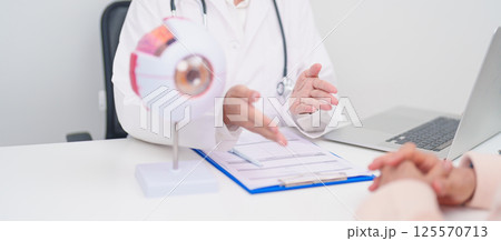 Elderly Patient consulting Doctor to Eye disease, Senior Medical Diagnosis. Anatomy Eye model for Cataract, Glaucoma, Age Related Macular Degeneration, Diabetic Retinopathy, Vitreous, health concept 125570713