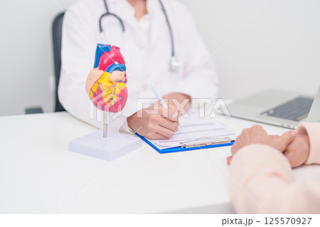 Doctor with Heart anatomy model. Elderly Patient consultation medical health for Cardiovascular Diseases, Atherosclerosis, Hypertensive, Heart attack, heart failure and world Heart day concept Doctor with Heart anatomy model. Elderly Patient consultation medical health for Cardiovascular Diseases, Atherosclerosis, Hypertensive, Heart attack, heart failure and world Heart day concept 125570927