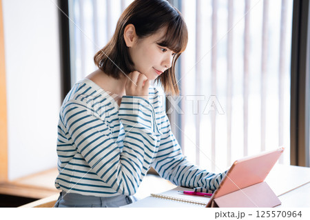 タブレットを使って勉強する若い女性 125570964