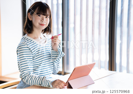 タブレットを使って勉強する若い女性 タブレットを使って勉強する若い女性 125570968