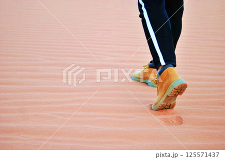 Person walking on the Wadi Rum desert in Jordan where the most Mars like terrain on earth. Person walking on the Wadi Rum desert in Jordan where the most Mars like terrain on earth. 125571437