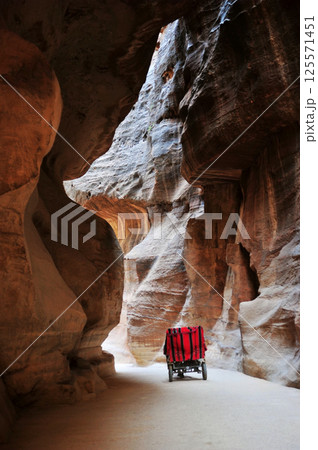 A carriage is driving on a path between cliffs in Petra, Jordan 125571451