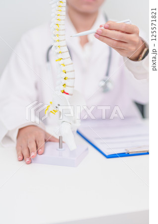 Elderly Patient consulting Doctor with Spine anatomy for Spinal Cord Disorder and disease, Back pain, Lumbar, Sacral pelvis, Cervical neck, Thoracic, Coccyx, Orthopedist, chiropractic, Office Syndrome 125571821