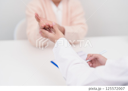 Elderly Patient Woman wrist pain and Consulting doctor. muscle ache from Carpal Tunnel Syndrome, De Quervain s tenosynovitis, rheumatoid, arthritis, gout, Parkinson disease and ergonomic healthcare 125572007