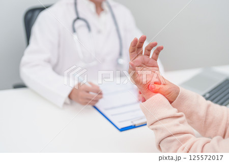 Elderly Patient Woman wrist pain and Consulting doctor. muscle ache from Carpal Tunnel Syndrome, De Quervain s tenosynovitis, rheumatoid, arthritis, gout, Parkinson disease and ergonomic healthcare 125572017