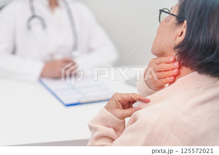 Elderly Woman having Shoulder and Neck and consulting doctor in hospital. Muscle painful due to Myofascial pain syndrome and Fibromyalgia, rheumatism, Scapular pain, Cervical Spine. ergonomic concept 125572021