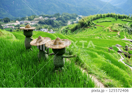 three scarecrows in front of terraces, Zhejiang Province, China 125572406