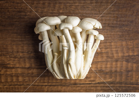 Raw white shimeji mushrooms on wooden table. Top view. Raw white shimeji mushrooms on wooden table. Top view. 125572506