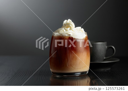 Iced coffee with whipped cream and caramel sauce and cup of black coffee. 125573261