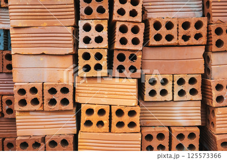 pile of modern hollow red bricks on construction site 125573366
