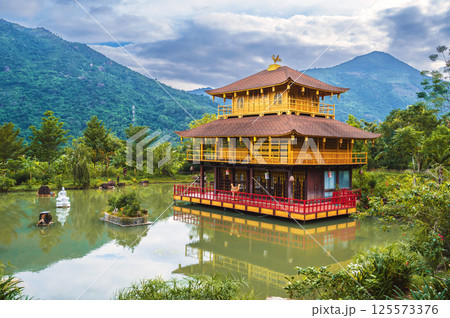 Landscape with Asian Buddhist Temple on water on pond at the Vietnamese Nghia Son Pagoda in mountains in Nha Trang in Vietnam in Asia Landscape with Asian Buddhist Temple on water on pond at the Vietnamese Nghia Son Pagoda in mountains in Nha Trang in Vietnam in Asia 125573376