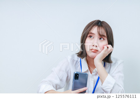 頬杖をついて考え事をする若い女性 125576111