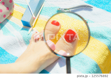 Woman magnifying pedicure 125576892