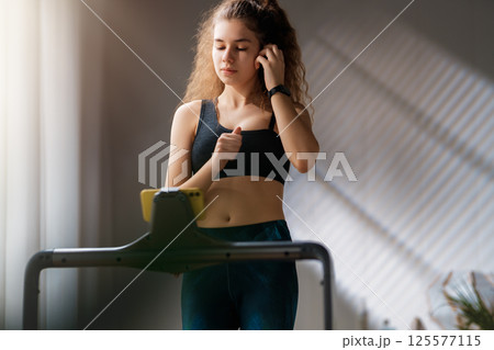Young woman running on a treadmill indoors Young woman running on a treadmill indoors 125577115