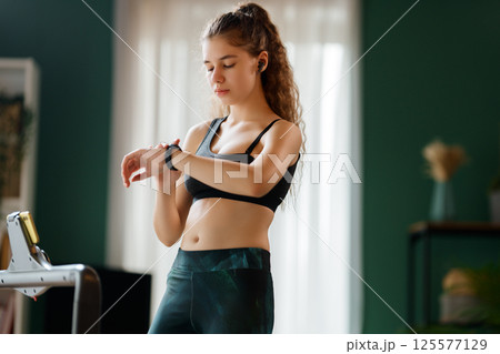 Young woman running on a treadmill indoors 125577129