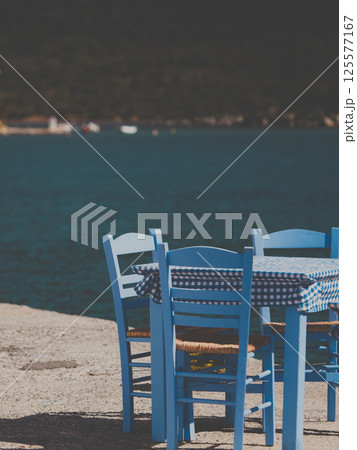 Open cafe outdoor restaurant in Greece on sea shore 125577167