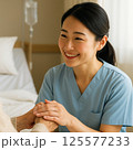 高齢者の手を握る女性看護師 125577233