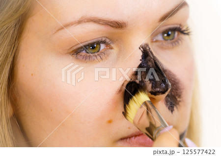 Girl being apply carbo mask to skin face 125577422