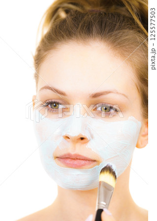 Girl apply green mud mask to face Girl apply green mud mask to face 125577503
