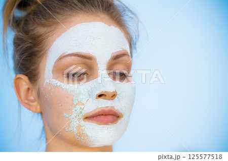 Girl removes dry white mud mask Girl removes dry white mud mask 125577518