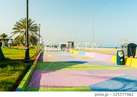 Kalba Corniche in Sharjah United Arab Emirates (UAE) on a beautiful day walking along the Gulf of Oman near the city. with beautiful yellow flowers 125577862