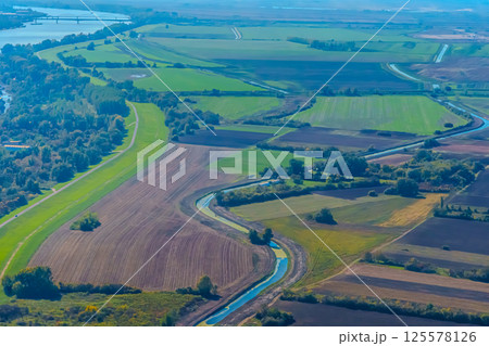 Aerial view of valley with farm fields, pond and Danube river. High quality photo 125578126