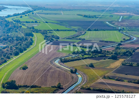 Aerial view of valley with farm fields, pond and Danube river. High quality photo 125578127