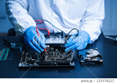 Hands repairing electronic devices. Electronic technician. Hands repairing electronic devices. Electronic technician. 125578221