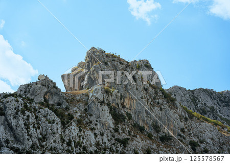 Large rocky mountain in the sun under a blue sky 125578567