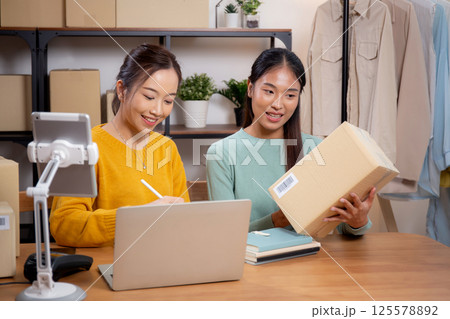 Two young asian woman working while planning online business and checking order. 125578892