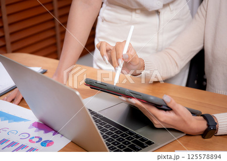 Closeup hand of two young asian businesswoman planning and strategy about marketing and financial. 125578894