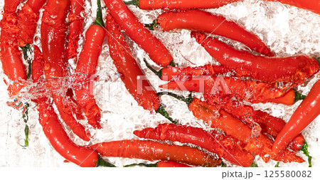 Vibrant Chili Peppers Washed in Water Close-Up 125580082