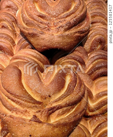 baking heart-shaped buns with swirls at bakery during morning rush for fresh pastries. close up. baking heart-shaped buns with swirls at bakery during morning rush for fresh pastries. close up. 125581417