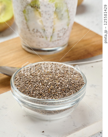 Clear glass bowl filled with dry chia seeds, top view 125581429