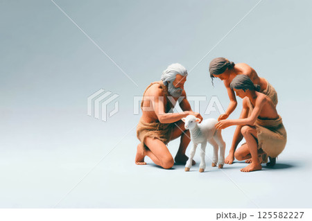Primitive people stroking a small sheep. Space for text. 125582227