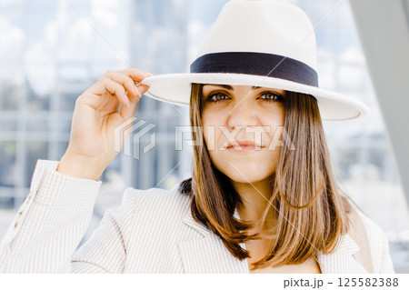 Portrait of a cheerful smiling woman wearing a stylish hat and glasses outdoors close up. Portrait of a cheerful smiling woman wearing a stylish hat and glasses outdoors close up. 125582388