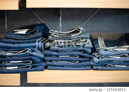 Many jeans in closet. Stack of jeans on shelf. Concept of buy , sell , shopping and jeans fashion . Many jeans in closet. Stack of jeans on shelf. Concept of buy , sell , shopping and jeans fashion . 125583651
