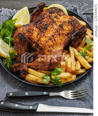 whole crispy skin roasted chicken on a platter 125584071