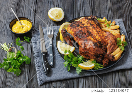 whole crispy skin roasted chicken on a platter 125584077