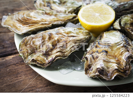 Raw oyster on wooden table 125584223