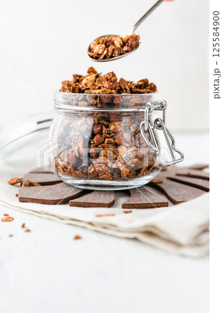Granola or baked oat flakes with chocolate and nuts. Healthy and simple breakfast. Granola or baked oat flakes with chocolate and nuts. Healthy and simple breakfast. 125584900