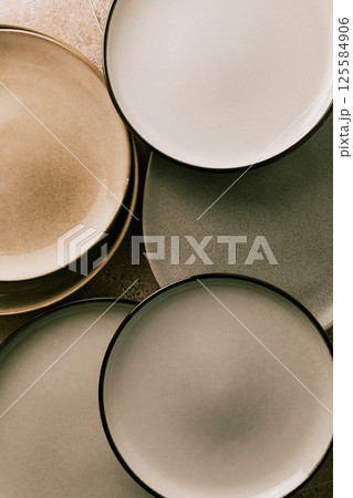 Top view of modern various ceramic plates on a kitchen table, abstract composition, vintage colors. Top view of modern various ceramic plates on a kitchen table, abstract composition, vintage colors. 125584906