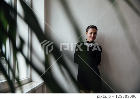 Beautiful slim woman with short haircut in black fashion dress 125585096