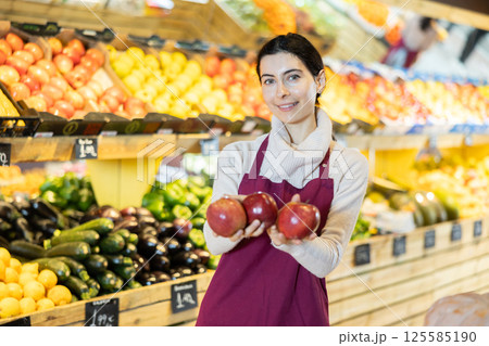 saleswoman offers ripe apples saleswoman offers ripe apples 125585190