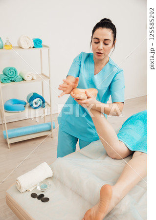 Woman on table at masseur on back massage in spa 125585292