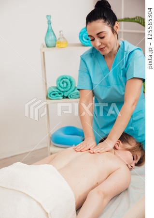 Woman Comes To A Relaxing Medical Massage To A Doctor Woman Comes To A Relaxing Medical Massage To A Doctor 125585304